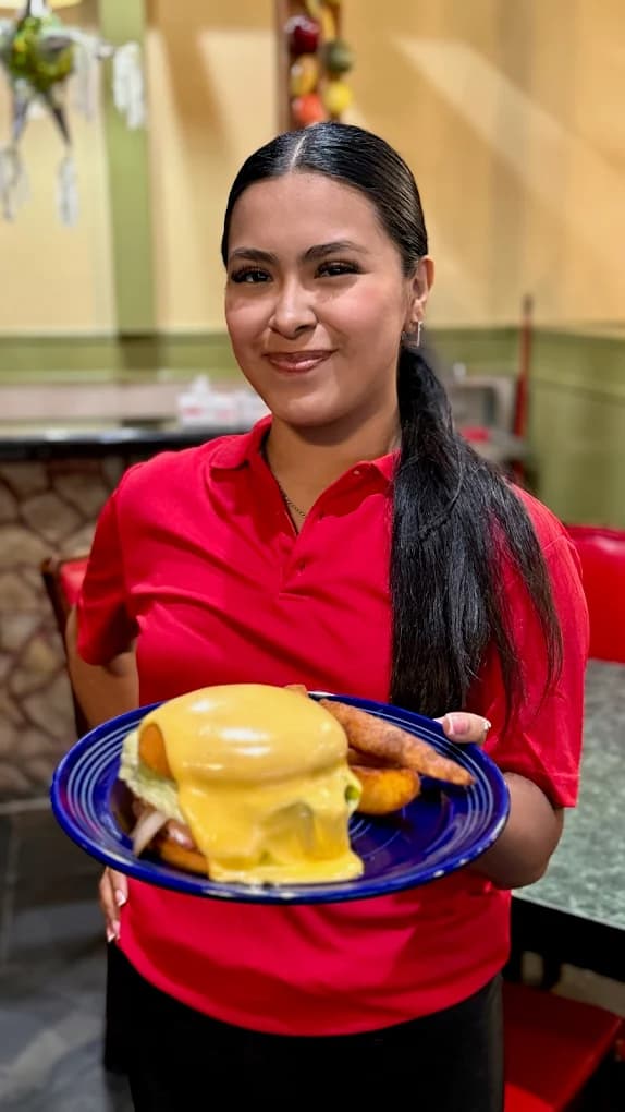Server at Las Piñatas Kitchen presenting a fresh Mexican plate in Tomball, TX